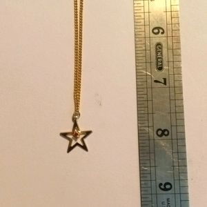 16" gold tone chain with golden star pendant and an amber colored cubic …